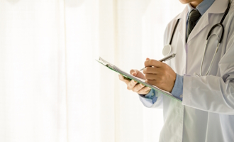 a doctor making notes on a patient chart