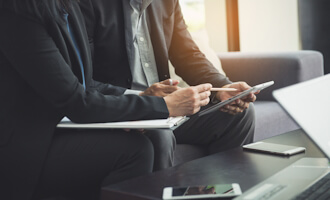 two business people doing an audit on a tablet